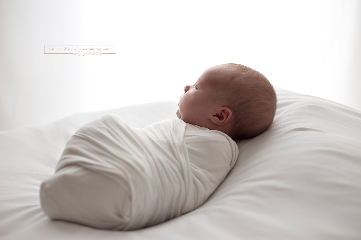 Das kleine Neugeborene gegen das Licht fotografiert