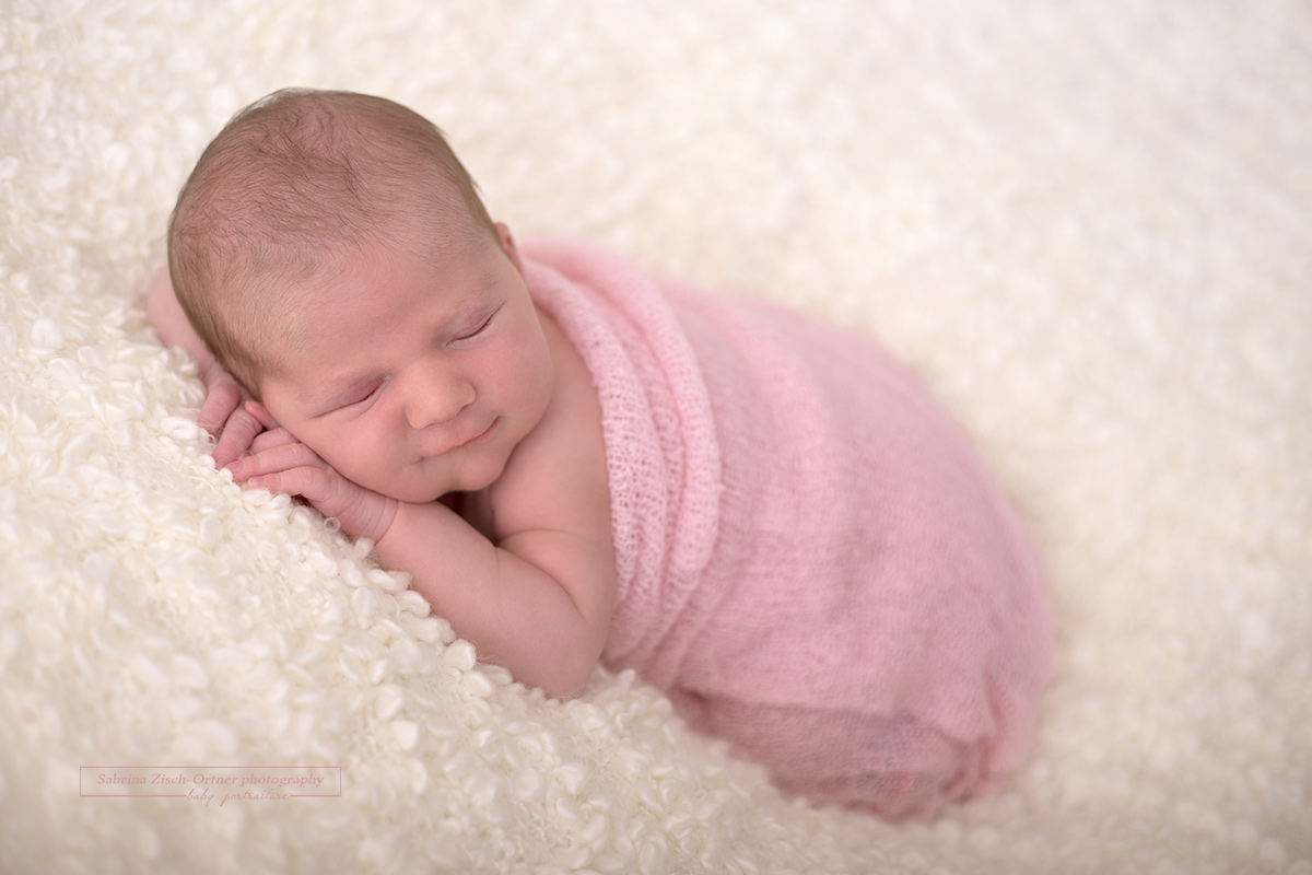 ein Lächeln das verzaubert von neugeborenen Mädchen bei ihrem ersten Fotoshooting