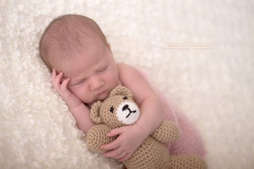 winzig kleiner Teddybär wird beim Fotoshooting umarmt