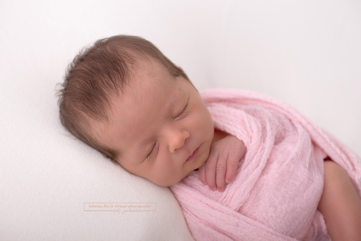 natürliches Portrait das Detail der Wrap Technik zeigt und ein wundervolles neugeborenes Mädchen