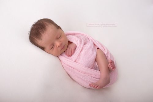 ein liebes herziges schlafendes Baby gewrapped in Rosa von Sabrina Zisch-Ortner