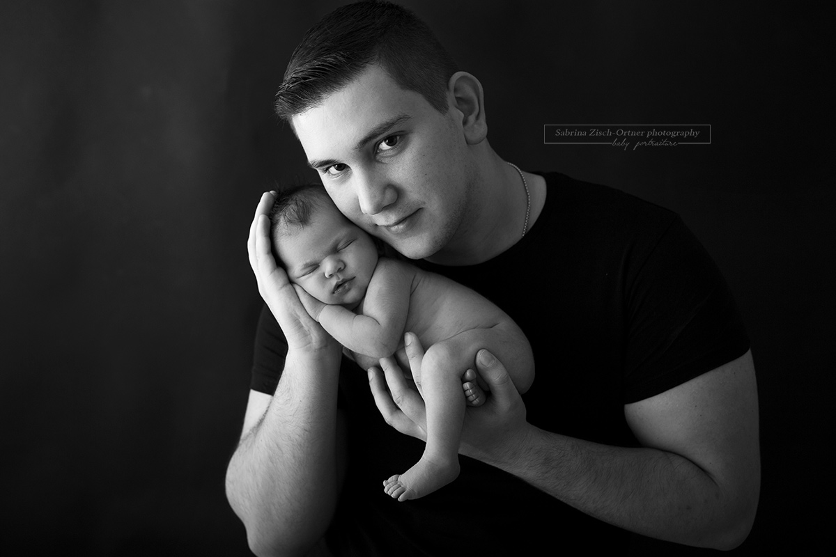 Papa hält seine neugeborene Tochter in seinen Händen