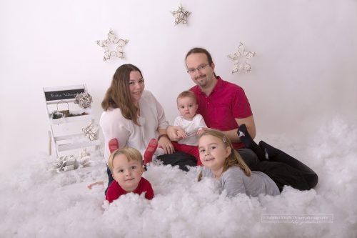 Weihnachtliches Familienfoto mit Schnee einer fünfköpfigen Familie