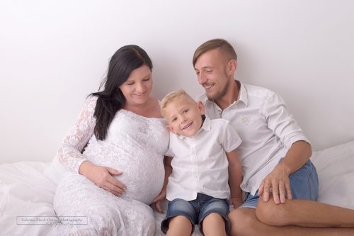 glückliches Familienfoto mit Babybauch und lächelnden großen Bruder gemacht von Sabrina Zisch-Ortner