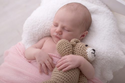 Baby kuschelt mit selbstgehäkelten Teddybär