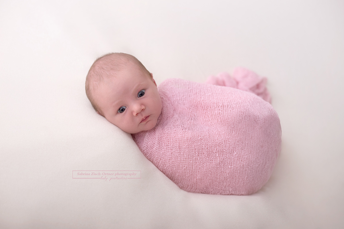 Baby in rosa Wrap eingewickelt