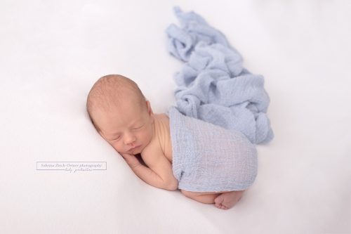 Baby mit blauen Wrap eingewickelt