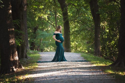 Babybauchfotos im Wald mit grünen extra geschneiderten Schwangerschaftskleid