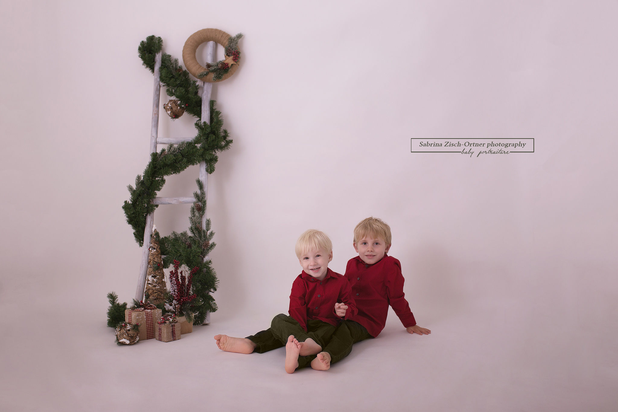 zwei Jungs schauen strahlend in die Kamera beim Weihnachtsfotoshooting