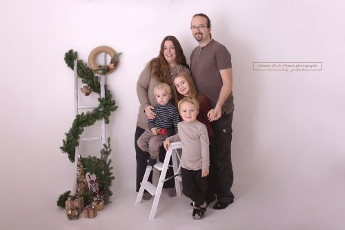 stehendes weihnachtliches Familienfoto einer fünfköpfigen Familie