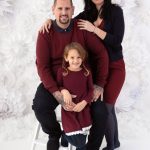 Familie in Rot vor den weißen Schneeflocken bei ihrem Fotoshooting