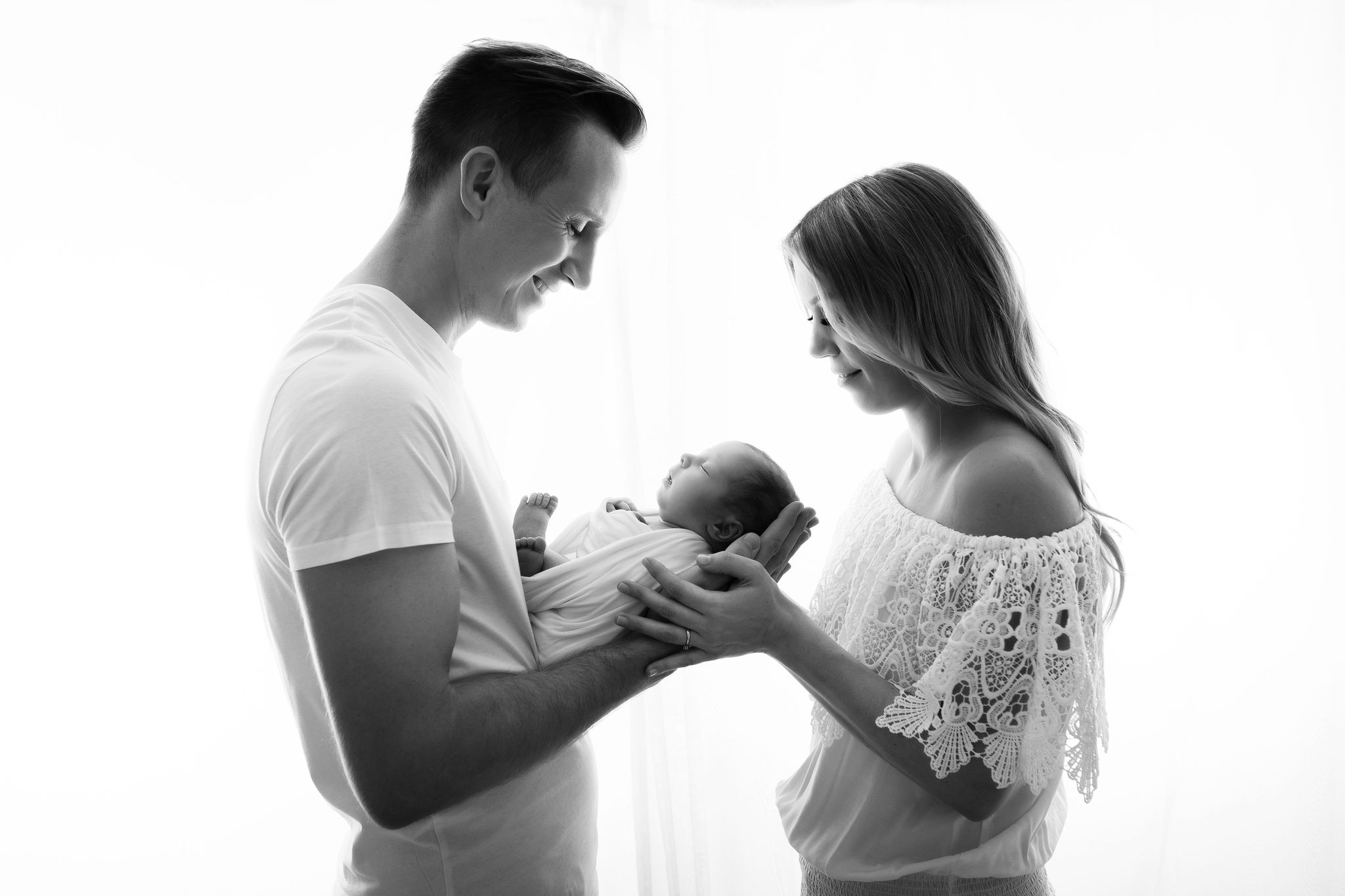 Schwarz Weiß Portrait zeigt frischgebackenen Eltern halten ihr neugeborenes Baby in Händen