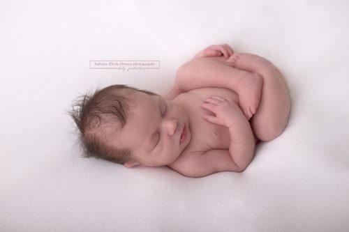 ein kleiner Wurm beim Neugeborenenfotoshooting in Huck Finn Pose am Beanbag