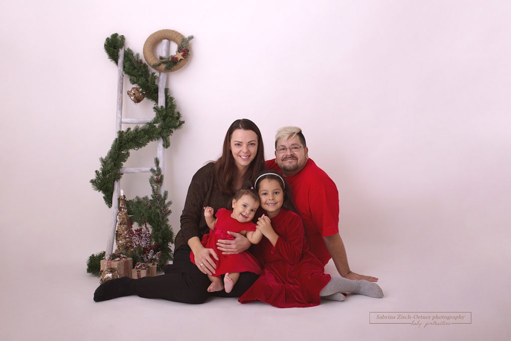 Familie in der passenden Farbe Rot für das jährliche Weihnachtsfotoshooting