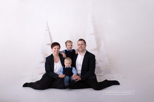 sitzendes Familienfoto im vorbereiteten und selbst ausgedachten Weihnachtssetup