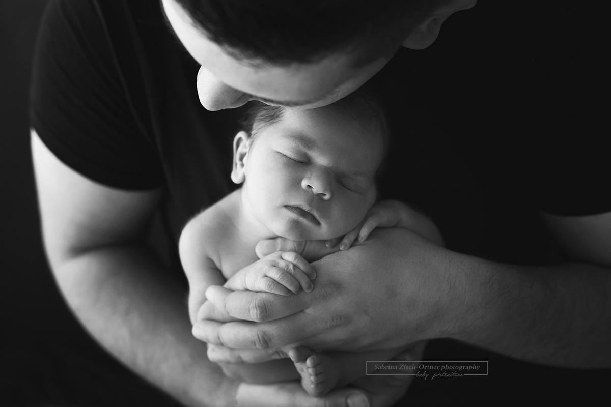 wunderhübsches Knuddelfoto von Papa und Baby welches das Kleine und Süße seiner Tochter zeigt