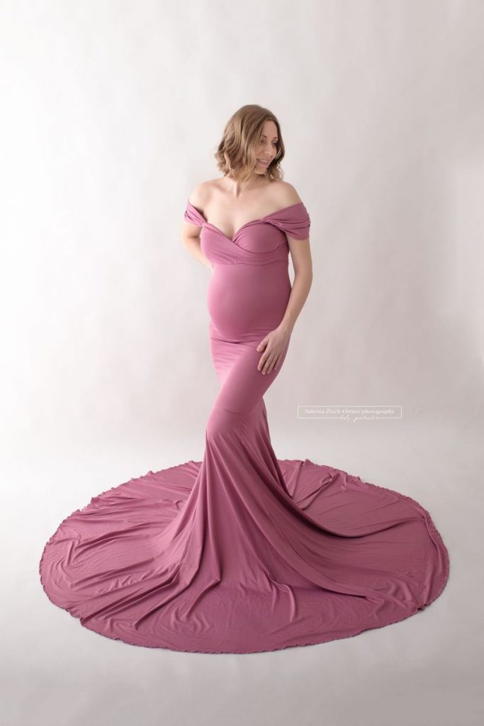 Schwangere beim Fotoshooting im Kleid in Mauve