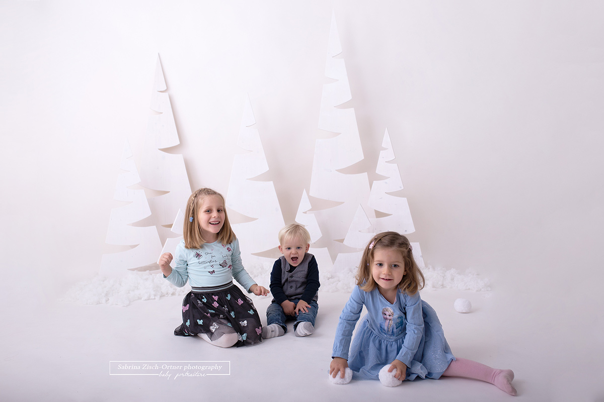 die drei jungen Geschwister haben ihren Spaß mit den Schneebällen beim Shooting im Fotostudio