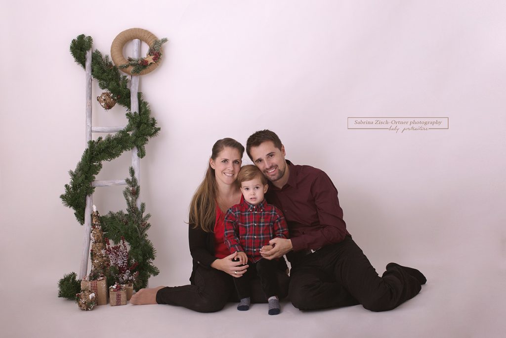 hübsches Familienfoto vor simplen Weihnachtsdeko