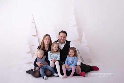 weihnachtliches sitzendes und kuschelnde Familienfoto vor meinem weihnachtlichen Setup