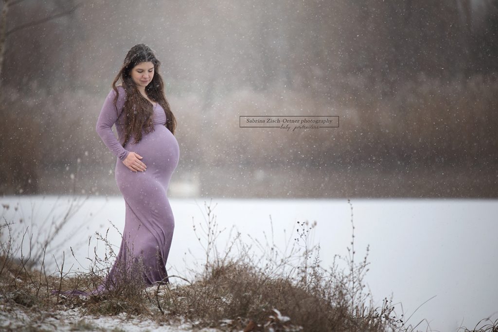 bequemes lila Babybauchkleid beim Outdoor Schnee Fotoshooting im Winter