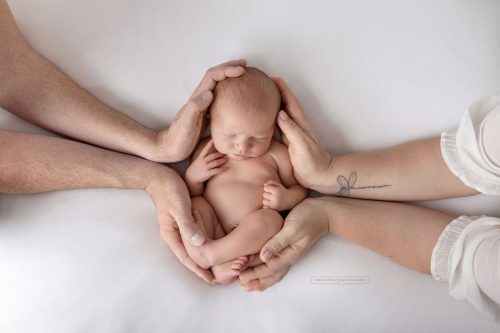 Baby in den Händen beider Elternteile