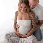 Familienfoto mit Babybauch in Spitze und hervorstechenden Tattoos