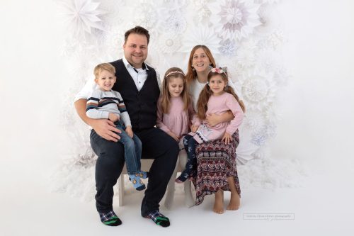 Fünfköpfige Familie strahlt in die Kamera bei ihrem Weihnachtsmini Termin