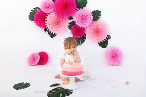 Mädchen kostet ganz vorsichtig bei ihrer Rosa Cake Smash Torte