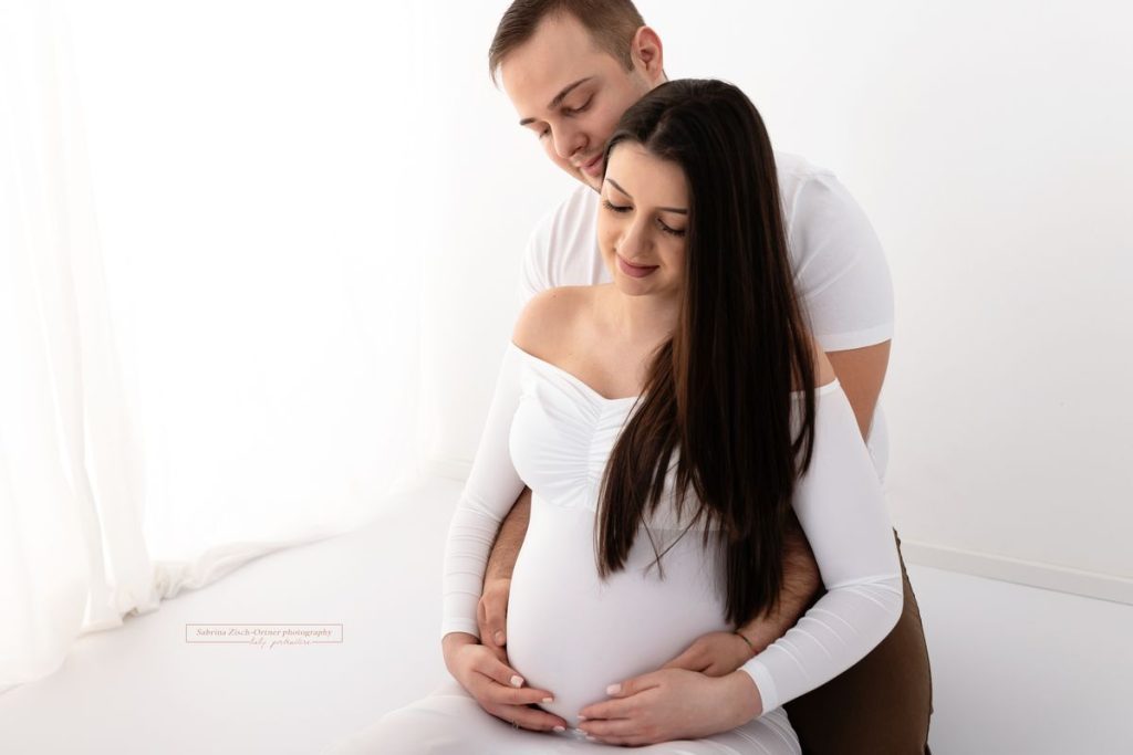 Mama und Papa kuschelndes Foto beim Babybauchshooting