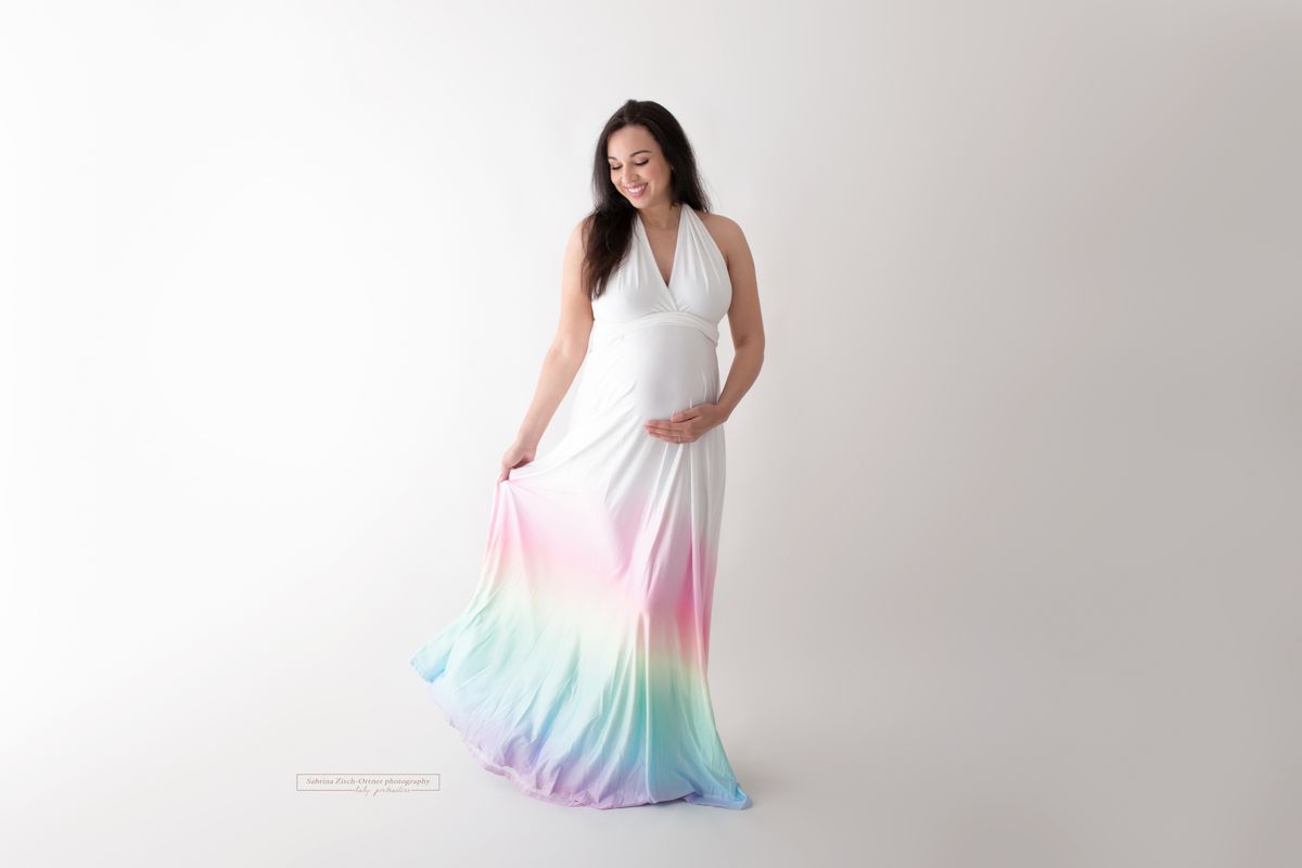 Regenbogenfarben im Ombrestil auf weißem Kleid beim Babybauchshooting