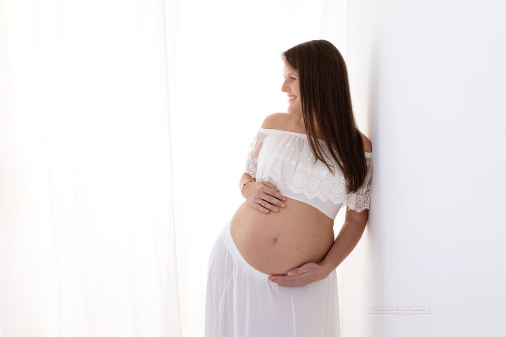Schwangere in handgemachter Babybauch Kleidung beim Fotoshooting