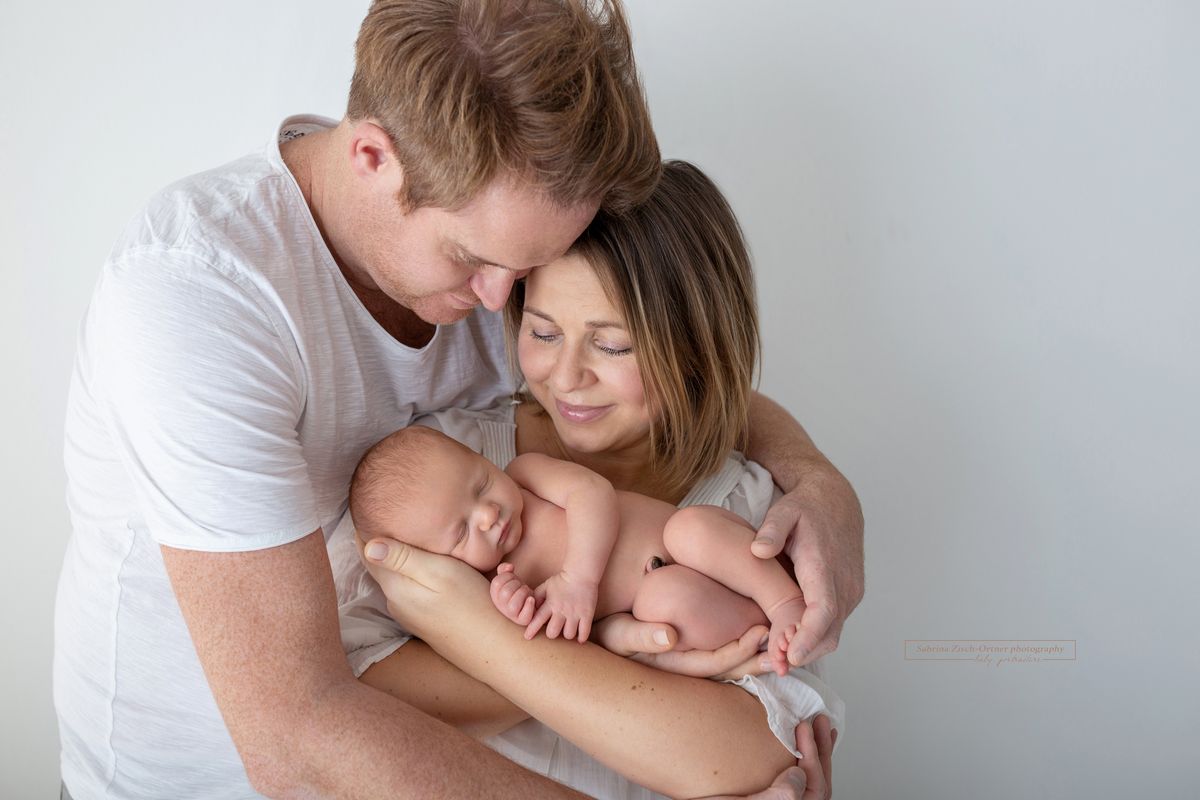 kuschelndes Familienfoto beim Babyfotoshooting