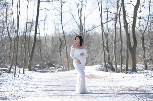 weißes Babybauchkleid im weißen Schnee beim Schwangerschaftsshooting in Wien