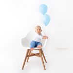 Baby auf Sessel mit Luftballons für sein 1 Geburtstag Fotoshooting
