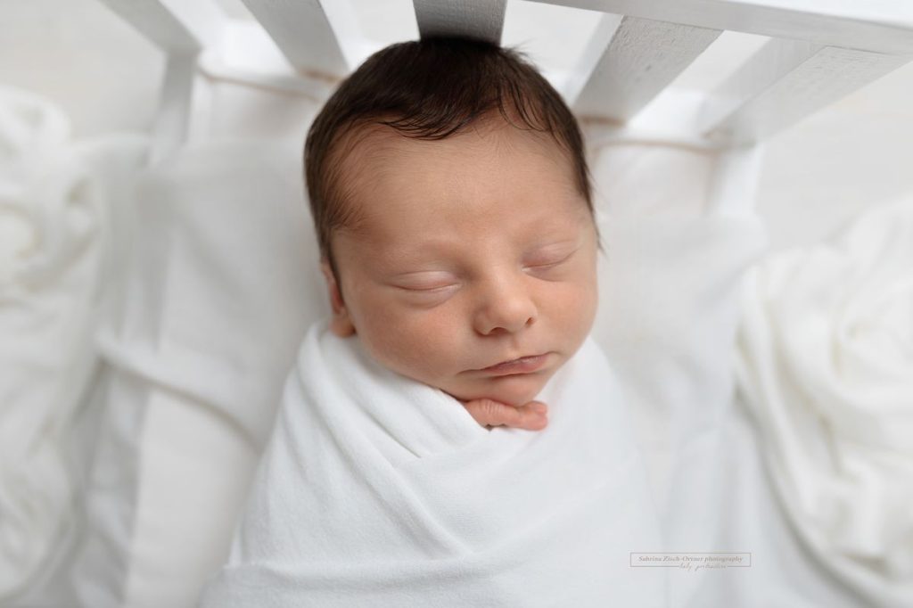 Baby im Bettchen beim Studiofotoshooting