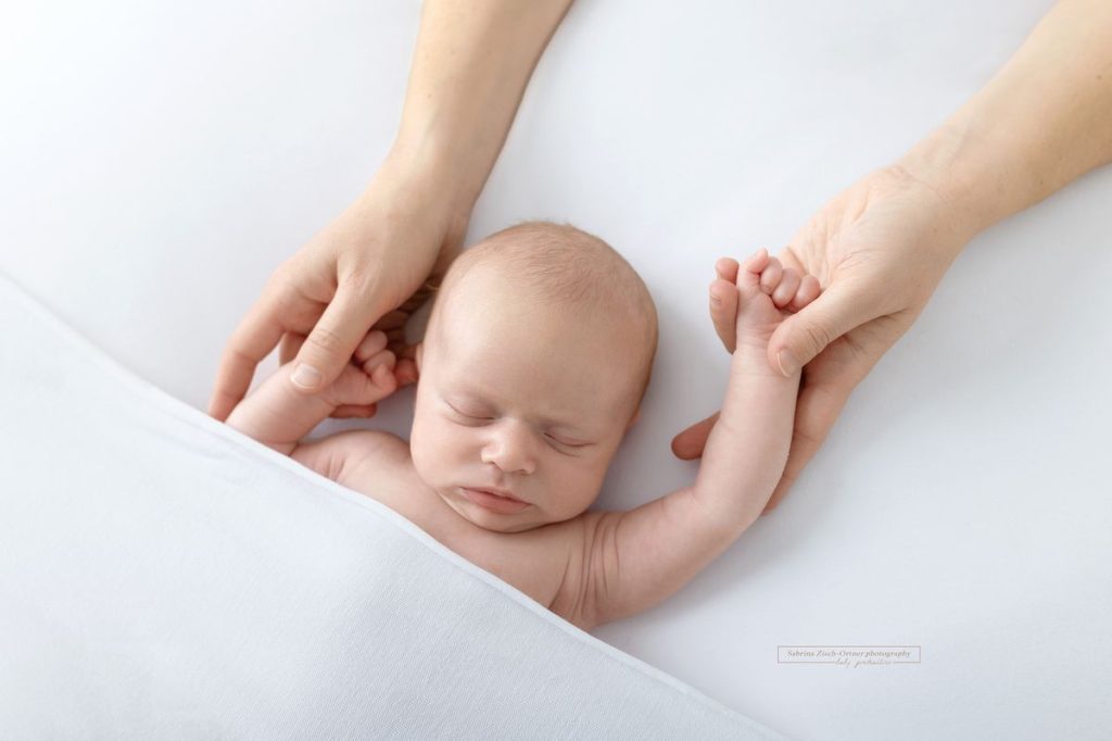 Baby in Mamas Händen beim Neugeborenen Shooting in Wien