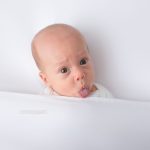 Baby zeigt die Zunge beim Fotoshooting