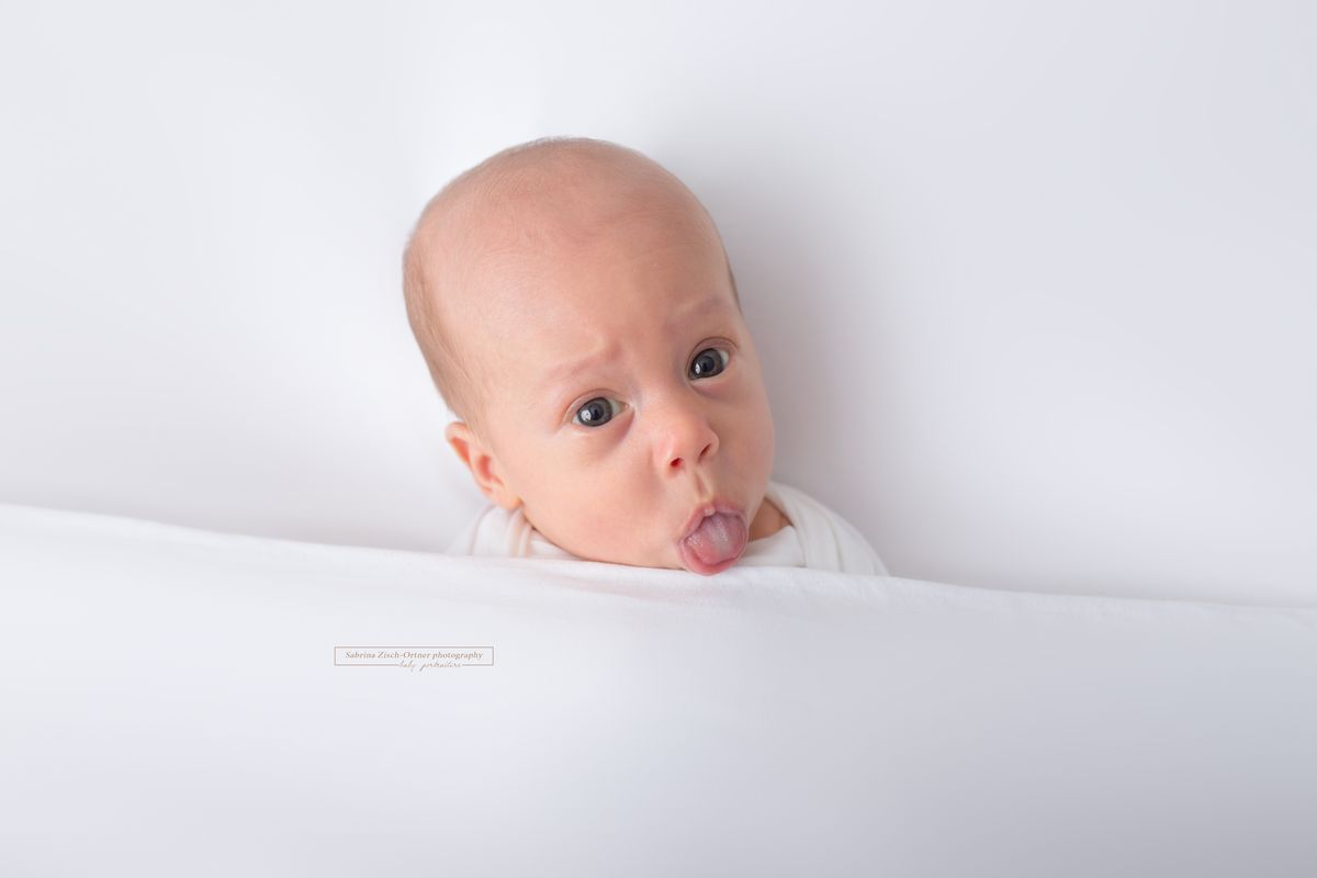 Baby zeigt die Zunge beim Fotoshooting