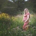 Babybauch der lachenden bald Mama blitzt in der Naturwiese hervor