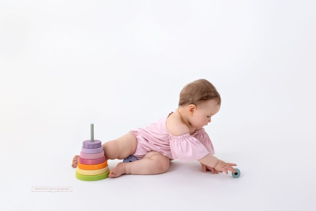 Grimms Regenbogen Stapelturm bei Fotoshooting mit Baby