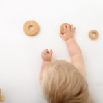 Holz Spielzeug und kleine Kinder Hände festgehalten beim Babyshooting