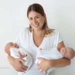Mama hält ihre zwei neugeborenen Zwillings Burschen in den Händen
