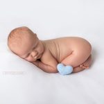Neugeborenen Posing mit blauem Herz als Accessoire