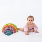 Regenbogen Holzspielzeug von Grimm für Babyfotos zum Meilenstein mit Mädchen
