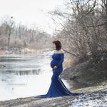 Schwangere sieht beim Fotoshooting auf den zugefrorenen See
