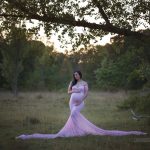Schwangerschaftsfoto nach Sonnenuntergang in rosa Babybauchkleid