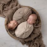 Zwillinge in braun gewickelt in braune Schale schlafend bei ihrem Baby Fotoshooting