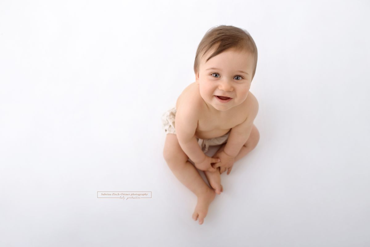 ein lächelnder 8 Monate alter Bub beim Shooting
