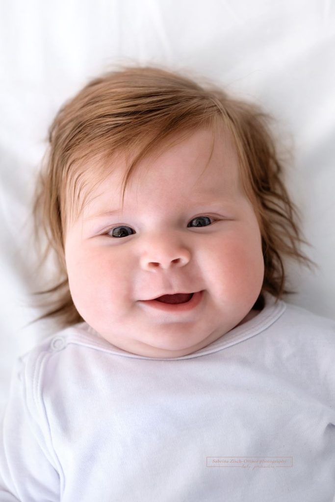 grinsendes 3 Monate altes Baby beim Fotoshooting